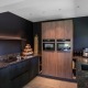 Moderne strakke donkere keuken met houten kastenwand